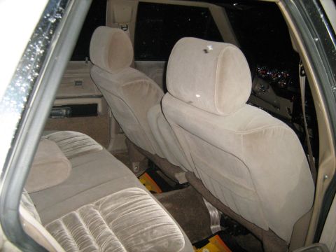 1988 Mercury Grand Marquis - The interior of a sedan shows the rear bench seat and the back of the front seats, illuminated by an unseen light source.