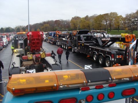 1992 Ford Bronco - A large fleet of tow trucks are parked in an outdoor lot under an overcast sky.