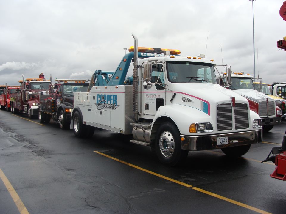 White tow truck with blue boom and 'Cooper Service' logo