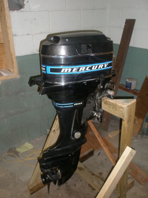 2007 Ford Bronco - A black Mercury outboard boat motor with blue accents is displayed on a wooden stand indoors.