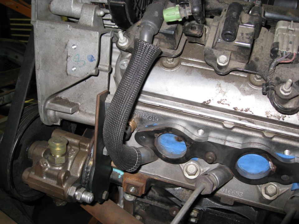 Engine with power steering pump and exhaust manifold