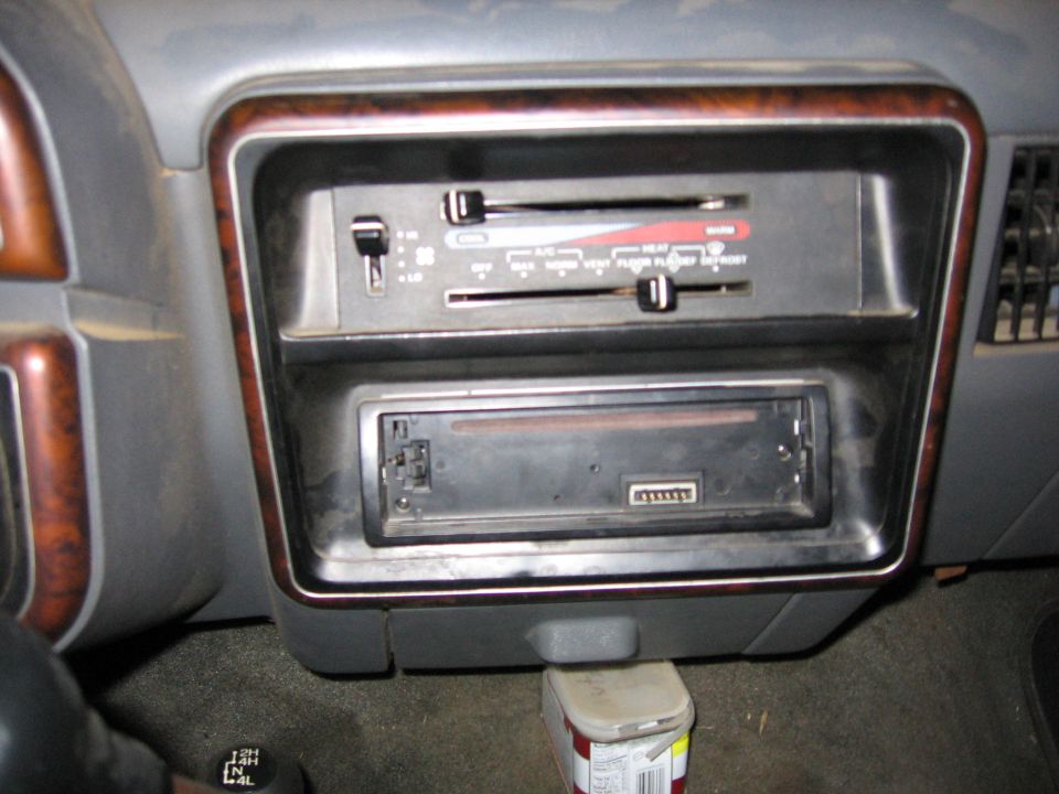 Dashboard with climate controls and a car stereo slot. Wood trim accents the dash