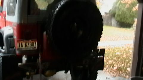 1989 Jeep YJ - Rear view of a red Jeep YJ, showing its spare tire carrier and license plate.