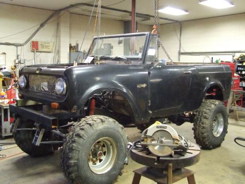 1967 International Scout 800 - This International Scout 800 is in a workshop, suspended by chains and equipped with large off-road tires.