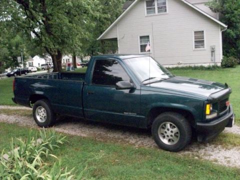 1995 GMC Sierra 1500 - This 1995 GMC Sierra 1500 pickup truck is parked on a gravel driveway next to a house.