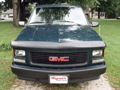 1995 GMC Sierra 1500 - Front view of a dark green 1995 GMC Sierra 1500, showing the grille and headlights.