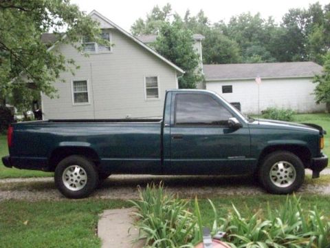 1995 GMC Sierra 1500 - Side profile of a 1995 GMC Sierra 1500 pickup truck with tinted windows.