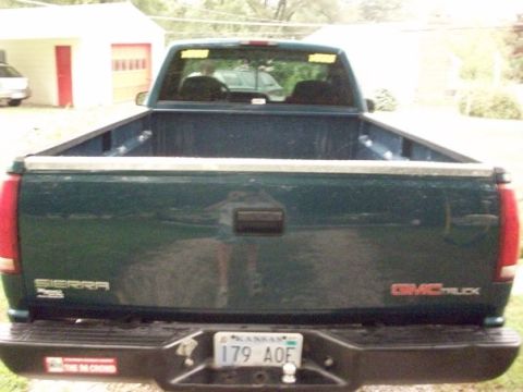 1995 GMC Sierra 1500 - Rear view of a dark green 1995 GMC Sierra pickup truck, showing the tailgate and bumper with a Kansas license plate.