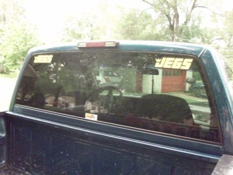 1995 GMC Sierra 1500 - Reflection in the rear window shows a garage and another vehicle.