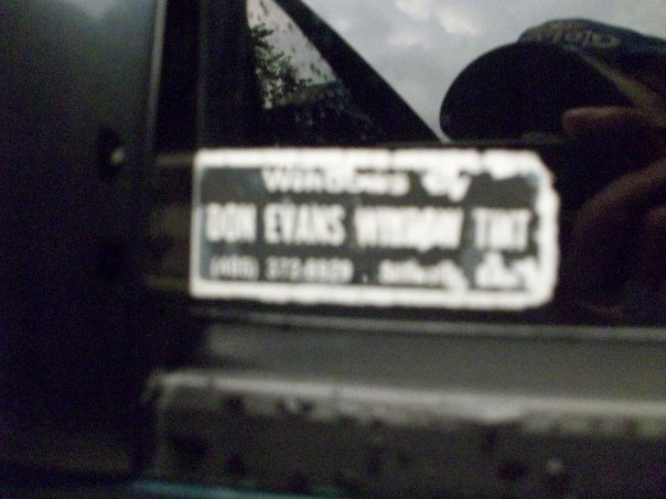 Sticker on dark vehicle door reads "DON EVANS WINDOW TINT" with phone number