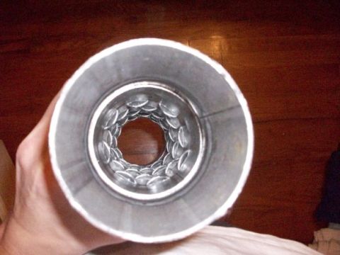 1995 GMC Sierra 1500 - Close-up view of an exhaust tip's perforated baffle, held by a hand.