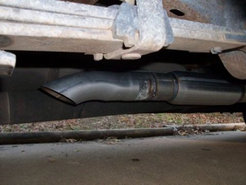 1995 GMC Sierra 1500 - Close-up view of a vehicle's aftermarket exhaust system, showing the muffler and tailpipe.