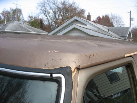 1978 Ford F-250 - Close-up of a weathered vehicle roof, revealing signs of age and wear on the metal surface.