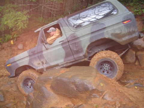 1989 Ford Bronco - A driver navigates a off-road course in a camouflage Ford Bronco, tackling challenging terrain.
