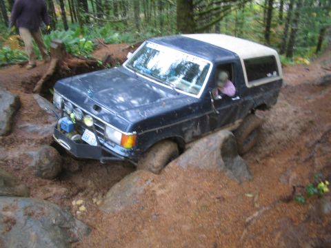 1989 Ford Bronco - This 1989 Ford Bronco tackles a challenging off-road course with muddy tires and a determined driver.