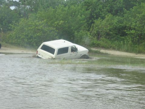 1989 Ford Bronco - This 1989 Ford Bronco appears to be stuck in a muddy, watery area, with its front end submerged.