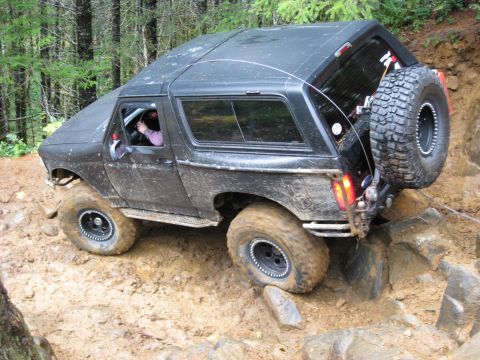 1979 Ford Bronco - This SUV is navigating a challenging off-road course with steep inclines and rocky terrain.