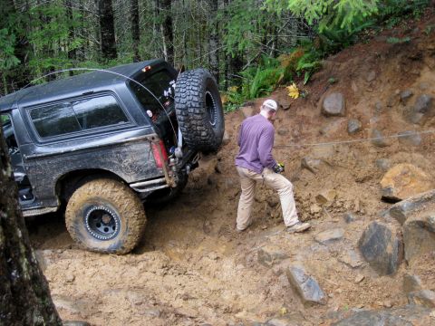 1979 Ford Bronco - A black SUV navigates a challenging muddy off-road course.