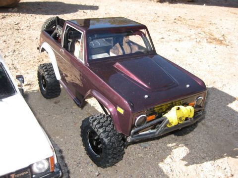 1988 Ford Bronco - A model Bronco with off-road tires and a winch sits beside a Toyota truck.