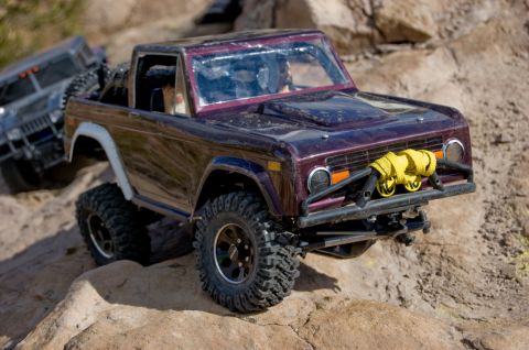 1988 Ford Bronco - Two remote control rock crawlers navigate a rocky terrain.