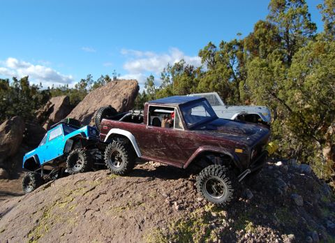 1988 Ford Bronco - RC trucks navigate a , rocky terrain under a clear blue sky.