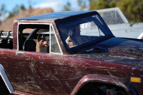 1988 Ford Bronco - A toy truck with figures in the windows sits outdoors with another vehicle in the background.