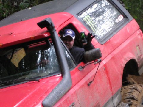 1979 Ford Bronco - Driver holds a Monster Energy can while sitting in a red 1979 Ford Bronco equipped with a snorkel.