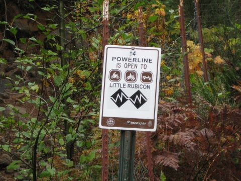 1979 Ford Bronco - A trail sign in a wooded area indicates that the powerline trail is open to various off-road vehicles.