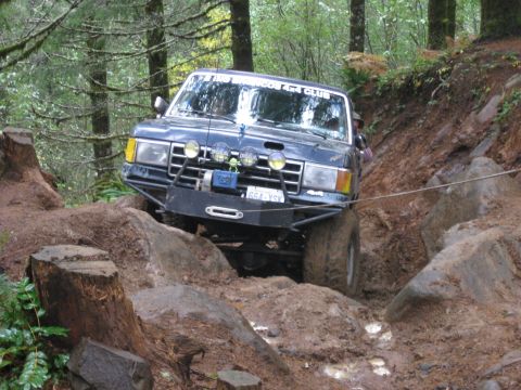 1979 Ford Bronco - This modified SUV is tackling a challenging off-road course with steep inclines and large rocks.