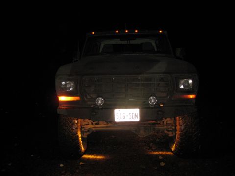 1979 Ford Bronco - Front view of a 1979 Ford Bronco at night, illuminated by its own lights.