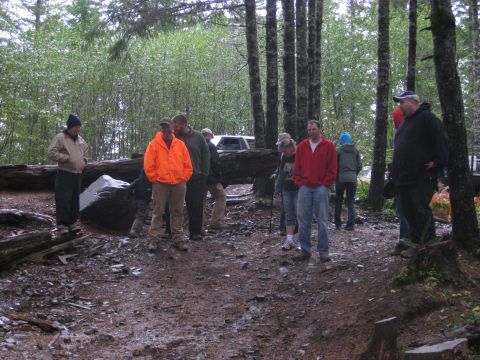 1979 Ford Bronco - A group of people gathered in a wooded area, with trees and debris surrounding them.