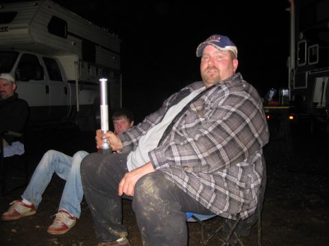 1979 Ford Bronco - Several individuals are gathered outdoors at night, seated in front of recreational vehicles.