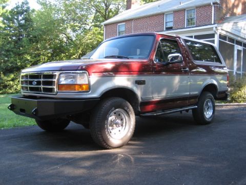 1996 Ford Bronco - This two-tone 1996 Ford Bronco is shown from a three-quarter front angle in front of a brick house.