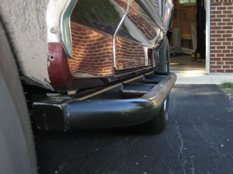 1996 Ford Bronco - Rear view of a 1996 Ford Bronco showing its bumper and side panel with reflections.