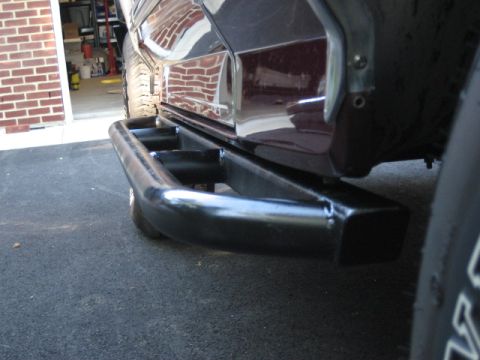 1996 Ford Bronco - Aftermarket rear bumper guard installed on a dark red vehicle.