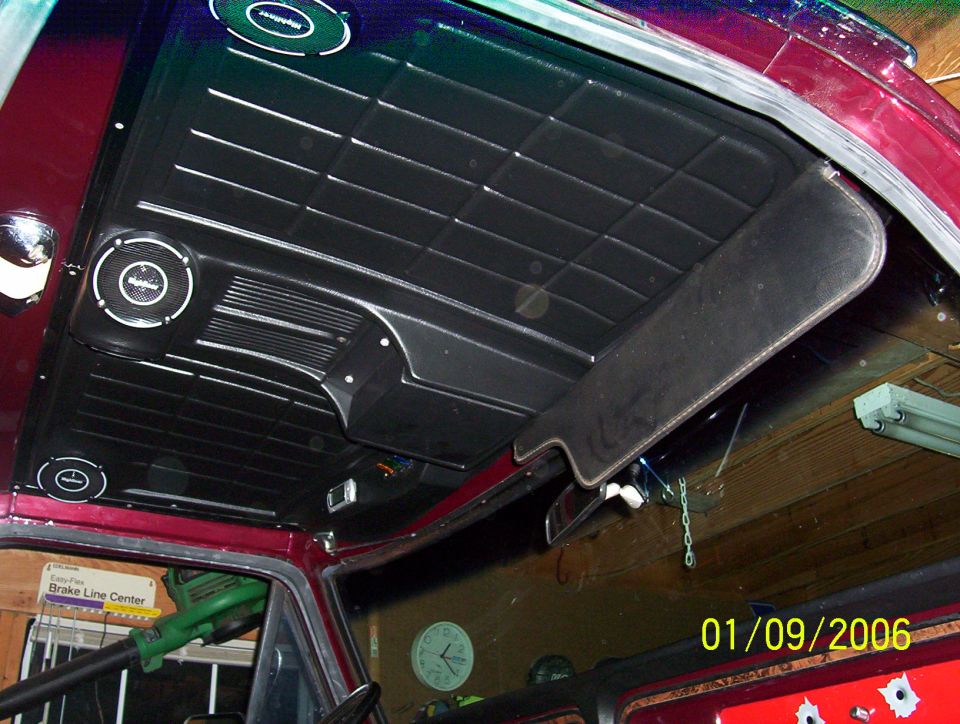 Black Bronco headliner with three speakers and flip-down visor, red trim, garage background