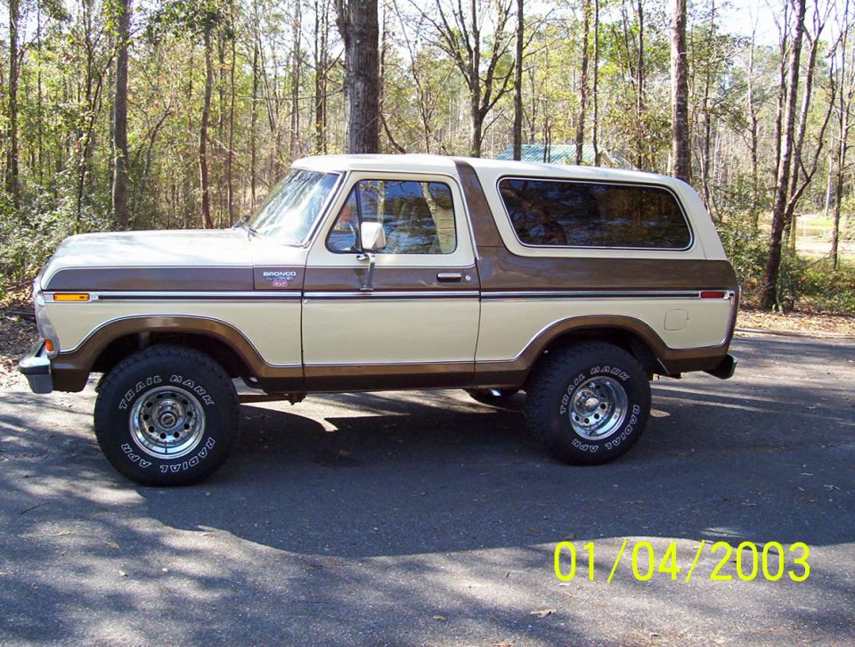 Two-tone beige and brown Ford Bronco side profile, showing chrome wheels and "Trail Mark" tires