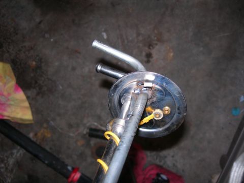 1984 Ford Bronco - A close-up view of a fuel pump sending unit with attached hoses and wiring.