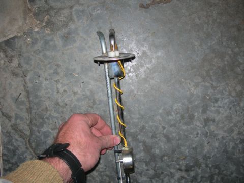 1984 Ford Bronco - A hand holds a fuel sending unit, which is a part of a vehicle's fuel system.