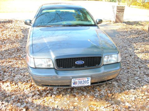 2000 Ford Crown Victoria - A 2000 Ford Crown Victoria is shown from the front, parked outdoors on a bed of fallen leaves.