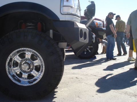1987 Ford Bronco - A heavily modified truck with large tires and an aftermarket bumper is shown at an outdoor event.
