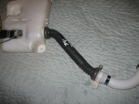 1996 Ford Thunderbird - A white plastic windshield washer fluid reservoir with a black pump and hose is shown.