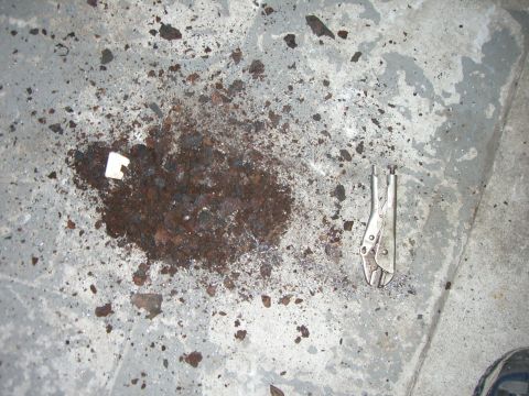 1988 Ford Bronco - Debris and a pair of vice grips lie on a concrete surface.