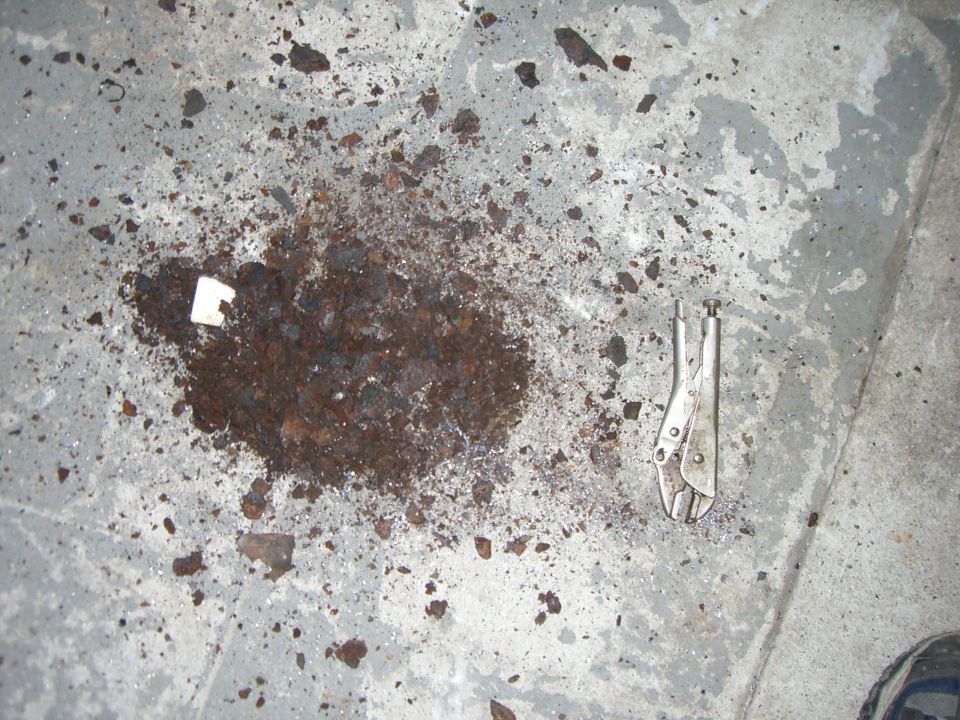 Debris pile and vice grips on a concrete floor