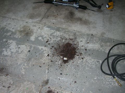 1988 Ford Bronco - A steering rack and some debris are visible on a concrete floor, along with a Supermotors logo in the lower right corner.