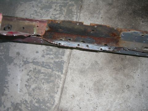 1988 Ford Bronco - Close-up of a heavily rusted and damaged metal component, likely from a vehicle's undercarriage.