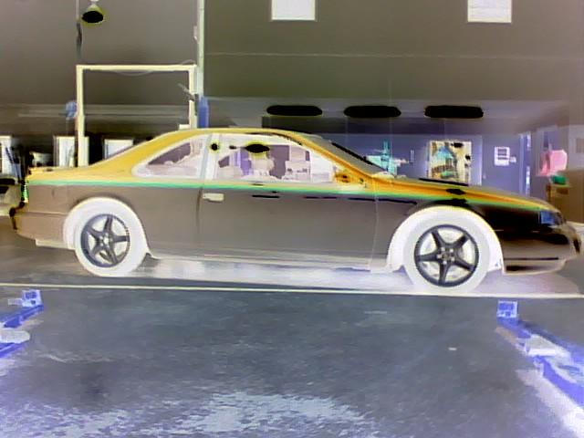 Side view of a 1994 Ford Thunderbird coupe, possibly undergoing paint work