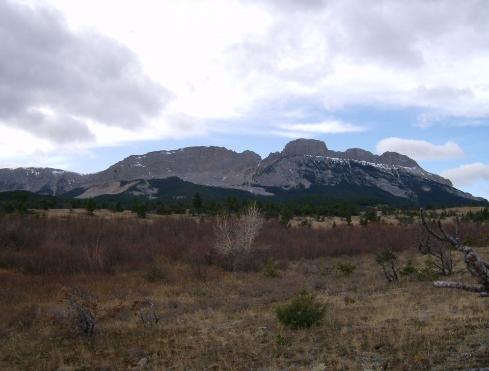 Mountain range with snow-capped peaks under a cloudy sky