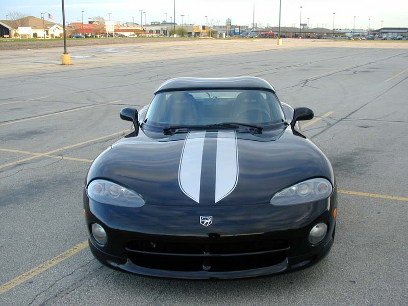 Front view of a black Dodge Viper RT/10 with white center stripes and hardtop in an empty lot
