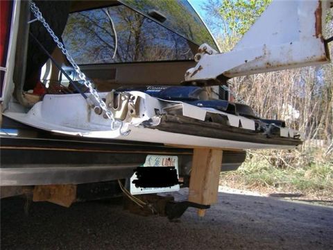 2000 Mercury Grand Marquis - The rear of a vehicle is shown with a tow hitch and trailer connection, secured with chains and a wooden block.